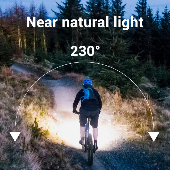 Cyclist at night using a 230 degree wide beam headlamp for natural trail lighting.