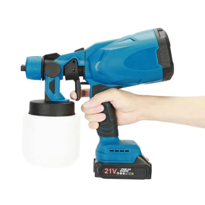 Hand holding a blue cordless paint sprayer showing ergonomic grip and compact size