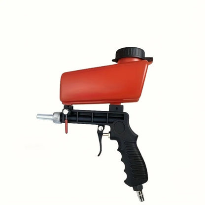 Handheld sandblasting gun removing rust from metal surface at high pressure