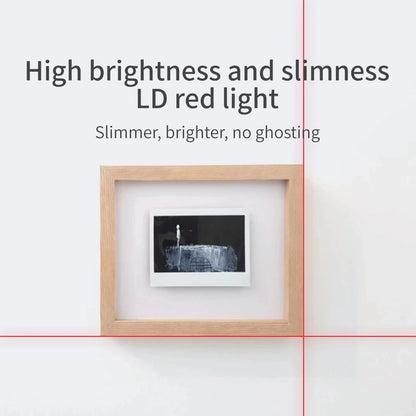 Bright red cross-line laser aligning a picture frame on a white wall.