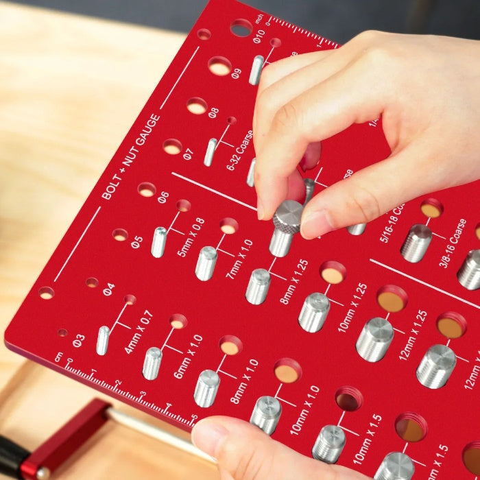 Hand testing a silver nut on a red Taskrafter bolt and nut thread checker board.