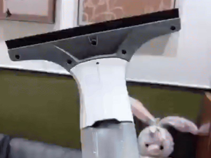 Hand using Taskrafter vacuum to clean a mirror for a streak-free interior shine