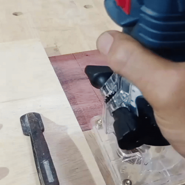 Close-up of adjusting the cutting depth on a wood router with transparent base.